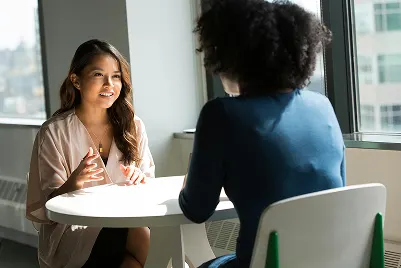 Two women at a table chatting
