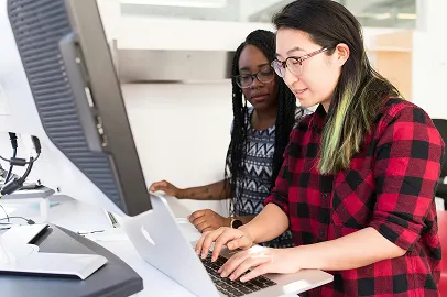 Two women working on their laptops